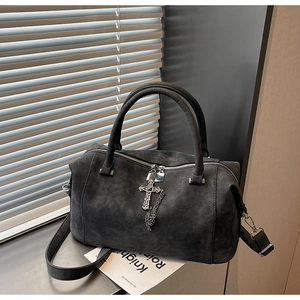 Dettaglio borsa grigio scuro satinata con croce in metallo vintage e catena argento