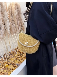 Detail der gelben Plüsch-Satteltasche mit Lederbesatz und goldenem Drehverschluss