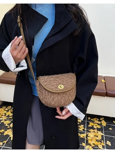 Braune Teddy-Satteltasche mit Lederbesatz getragen zu einem schwarzen Winterwollmantel