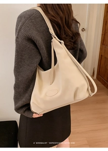 Detail of cream hobo shoulder bag with oval patch and adjustable silver buckle straps