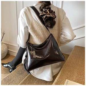Detail of glossy pleated leather hobo bag showing texture and large capacity fit