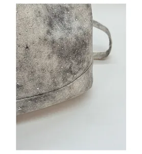 Close-up of vintage tote bag surface featuring grey-white tie-dye and silver stars