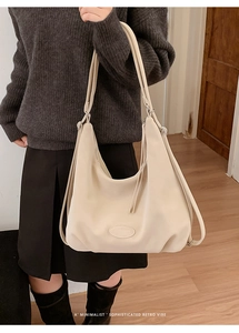 Detailansicht der beige Retro-Tragetasche mit langen Quasten und Lederaufnäher-Details