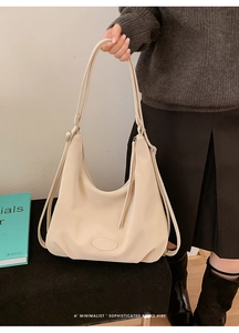Detail der minimalistischen beige Hobo-Tasche aus glattem Kunstleder mit Retro-Riemen