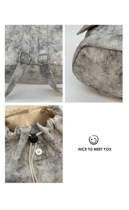 Detail of star pattern canvas backpack featuring metal buckles and drawstring closure