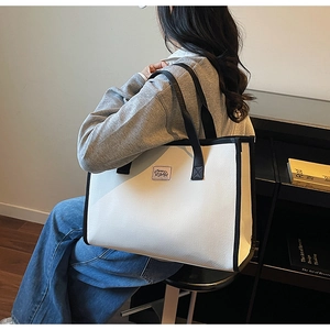 Détail du grand sac cabas contrasté noir et blanc avec anses robustes et logo frontal