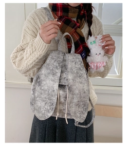 Detail of grey backpack with rabbit ears, white star pattern and drawstring closure