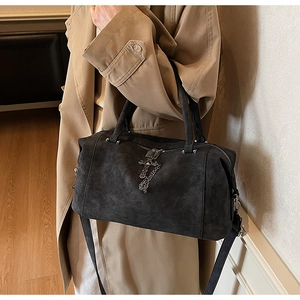 Dettaglio borsa tote grigio scuro in pelle smerigliata con pendente a croce e catenella