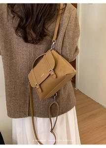 Borsa tote retrò in pelle marrone con fibbia in metallo indossata da una modella