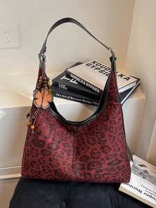 Red leopard print hobo bag with vintage floral charm on white display stand