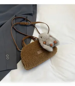 Detail of brown faux shearling mini crossbody bag with cute plush rabbit charm