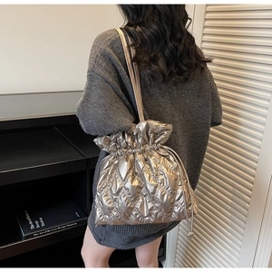 Macro shot of silver quilted bucket bag with metallic finish and drawstring detail