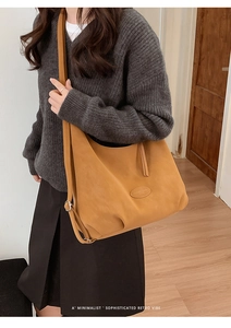 Detail der karamellfarbenen Shopper-Tasche mit ovalem Lederaufnäher und breitem Gurt
