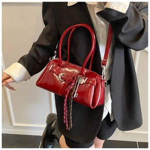 Polished red patent leather shoulder bag with silver buckle and braided key charm detail