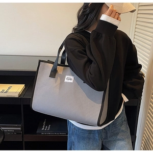 Détail du grand sac cabas à carreaux gris avec texture polyester et bandoulière noire
