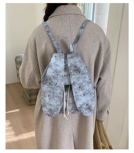 Detailed view of grey marble pattern backpack with creative 3D rabbit ears and drawstring