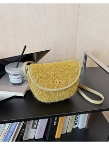 Detailansicht der gelben Plüsch-Satteltasche mit Lederbesatz und goldenem Drehschloss