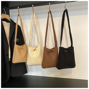 Detail of knitted bucket bags with vintage toggle buttons in khaki, beige, coffee, and black