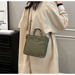 Detailed shot of an olive green nylon tote bag featuring durable fabric and twin handles
