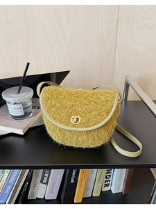 Nahaufnahme der gelben Plüsch-Satteltasche mit goldenem Schloss im Designerregal