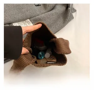 Internal capacity of brown knit bucket bag showing phone and cosmetics inside
