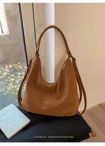 Detailansicht der Hobo-Tasche in Karamell mit Logo-Prägung und Doppelriemen