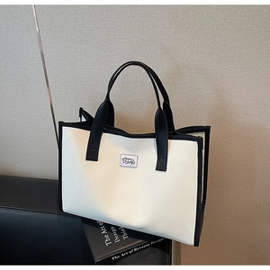 Détails du sac cabas contrasté avec texture cuir et finitions des poignées noires