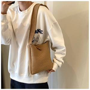 Détail de ce sac seau en tricot avec bouton en bois et texture beige élégante