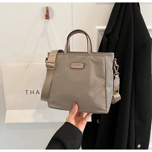 Detail of grey nylon tote bag with wide strap and CLEAROK metal logo for commuting