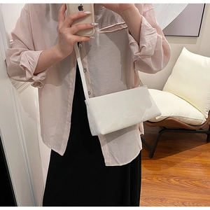 Mirror selfie showing the white minimalist crossbody bag with a slim strap for women