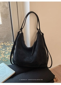 Detail einer schwarzen Vintage-Hobo-Tasche mit matter Ledertextur und Multi-Tragegurt