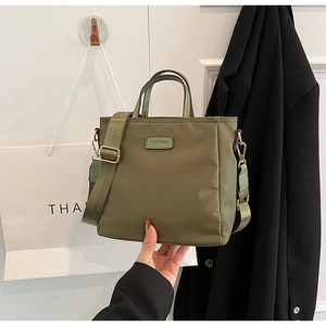 Detail of army green nylon handbag with double handles and metal CLEARUK logo plaque