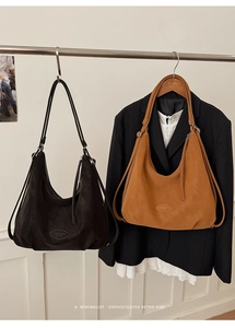 Details von zwei Hobo-Taschen aus Leder in Schwarz und Braun mit geprägtem Logo