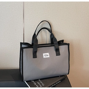 Détail du sac cabas à carreaux gris avec étiquette Mummy Bags et anses noires