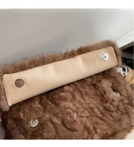 Dettaglio di chiusure magnetiche argentate su borsa in peluche marrone con interno beige