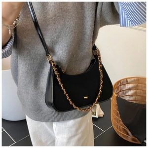 Detalle del bolso hobo de cuero brillante negro con decoración de cadena dorada