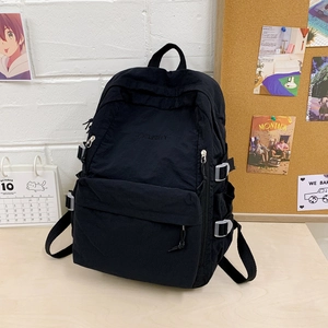 Nahaufnahme des schwarzen Nylon-Rucksacks mit weißen Schnallen und Logostickerei