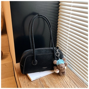 Détail du sac Boston en daim noir avec surpiqûres blanches et pendentif ours mignon