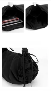 Detail of black nylon crossbody bag featuring adjustable side drawstring and spacious interior