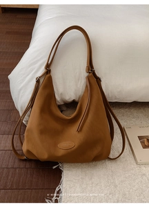 Detail der vintage braunen Ledertasche mit geprägtem Fashion-Logo auf weichem mattem Finish