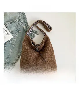 Detail of brown plush tote bag featuring gingham lining and drawstring closure