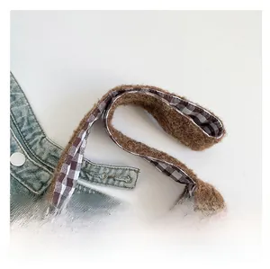 Detail of plush tote bag showing thick brown faux fur handle and checkered lining texture