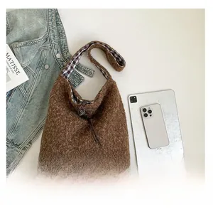 Detail of plush brown tote bag featuring checkered lining and drawstring leather closure