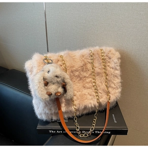 Dettaglio borsa tote in peluche rosa con catena dorata e ciondolo a forma di coniglio