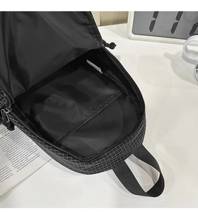Macro view of checkered crossbody bag showing spacious main compartment and fabric texture
