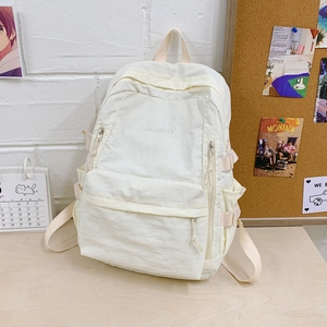 Detail eines weißen Nylon-Rucksacks mit Doherty-Stickerei und Seitenschnallen im Lifestyle