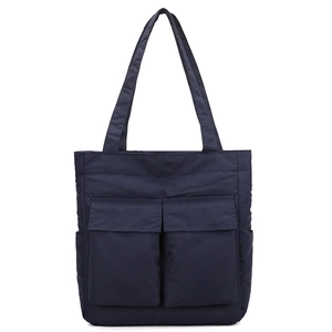 Detailed close-up of navy blue nylon tote bag showing double front flap pockets