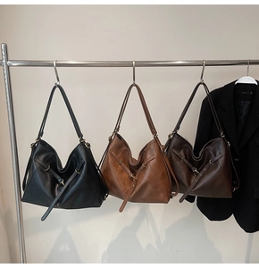 Detailed display of hobo tote bags in black, caramel, and dark brown on a hanger