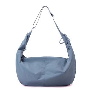 Detail of blue nylon crescent bag featuring adjustable ruched drawstring shoulder strap