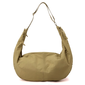 Detail of khaki nylon crescent bag showing durable fabric texture and side drawstring knots